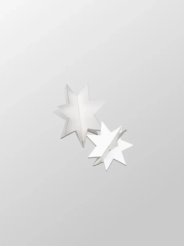 Stjärna 2-pack har två vita, åttauddiga stjärnor med 3D-pappersutskärning på en ljusgrå bakgrund, vilket återspeglar svensk design. De är centrerade med den ena stjärnan något överlappande den andra för extra elegans.